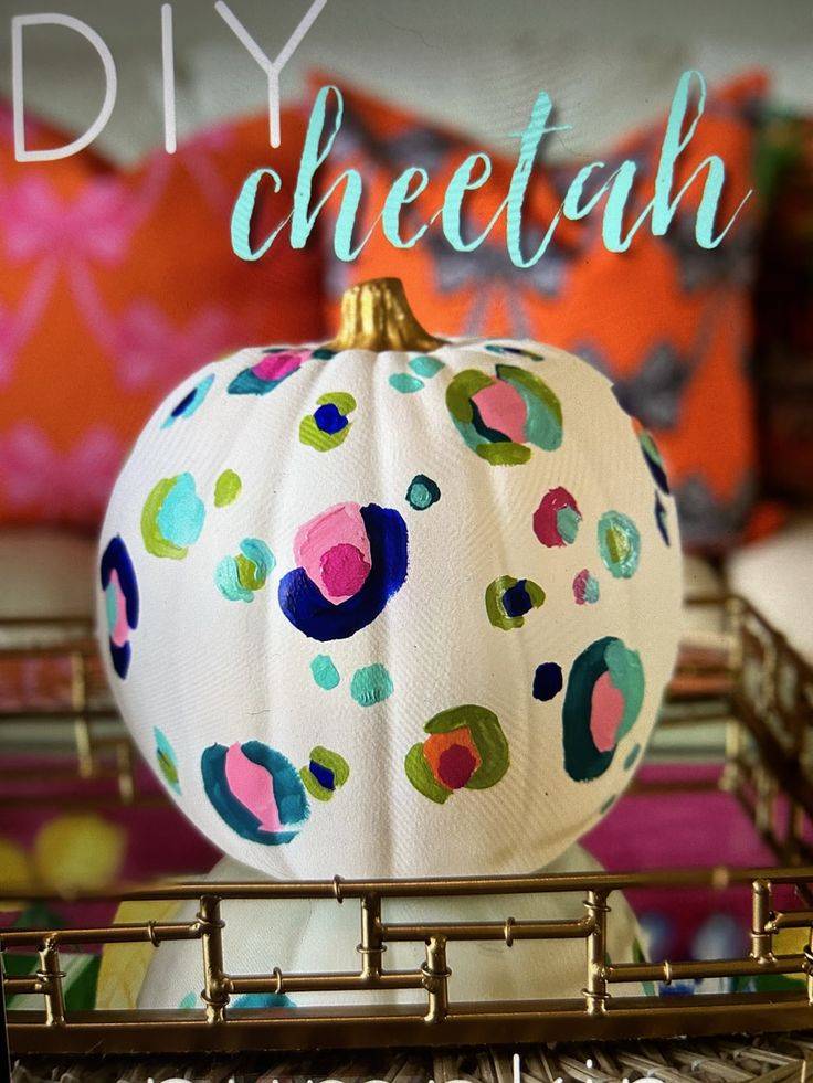White pumpkin hand painted with colorful cheetah spots in pink, teal, navy and lime